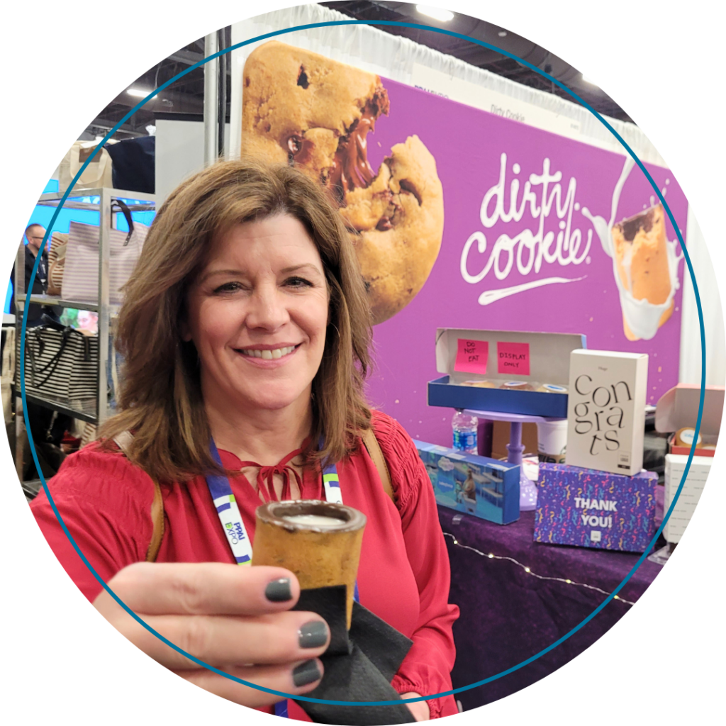 Traci Phillips holding a custom cookie cup from Dirty Cookie at PPAI Expo