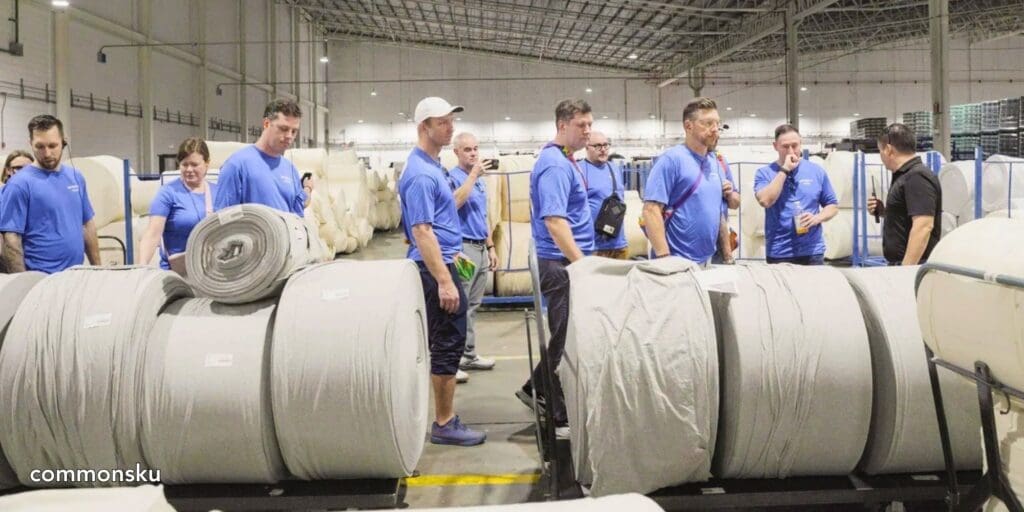 A photo of promotional product distributors looking at rolls of cloth used to make apparel in Honduras.