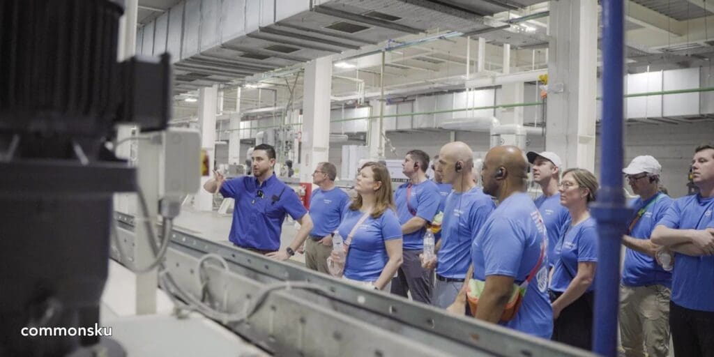 A photo of promotional products distributors looking at manufacturing equipment in a facility in Honduras.