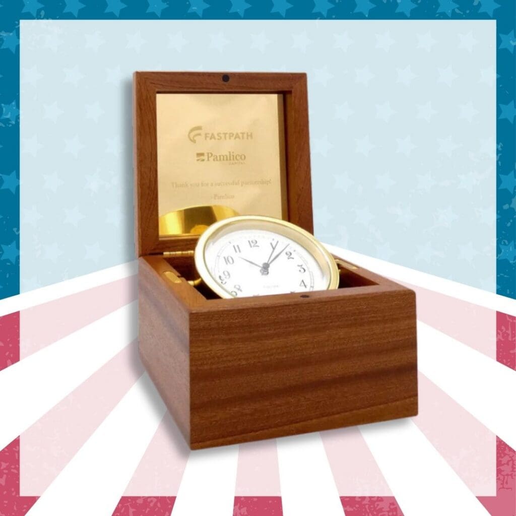 Polished brass boardroom clock displayed on a dark mahogany wooden base.